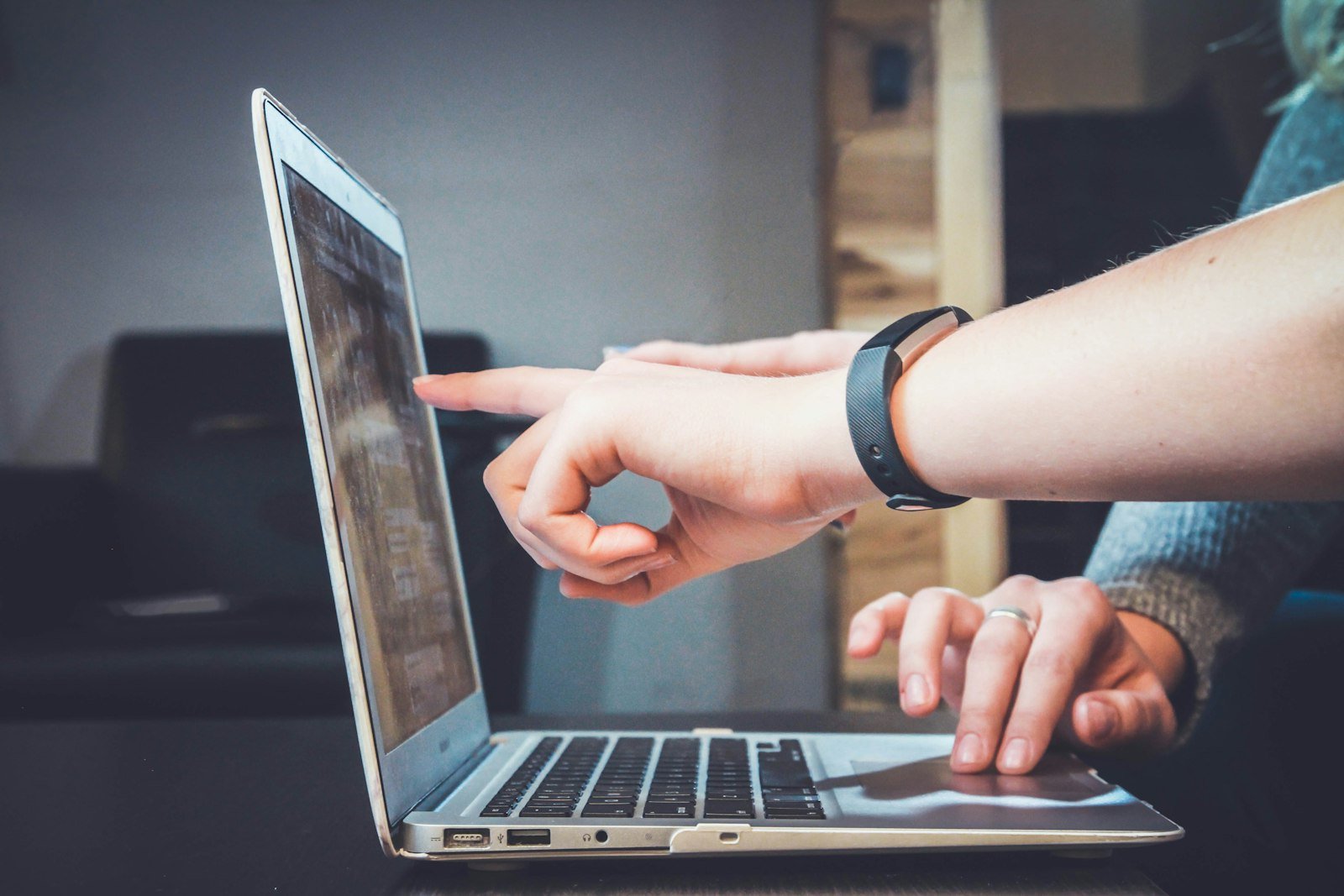 Two people reviewing an application together on a laptop